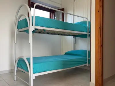 Letto o letti a castello in una camera di Casa Ambra - Villetta con vista, giardino e BBQ
