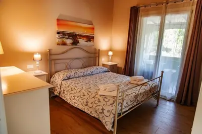 Letto o letti in una camera di Appartamento in residence con piscina