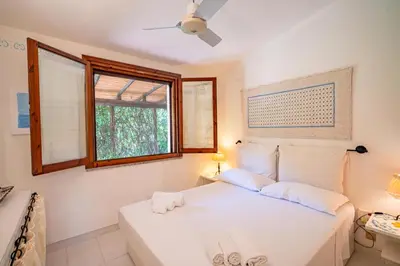 Letto o letti in una camera di Villa Ulivo - Spiaggia di Porto Giunco a piedi