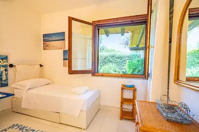 Letto o letti in una camera di Villa Ulivo - Spiaggia di Porto Giunco a piedi