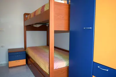 Letto o letti a castello in una camera di Appartamento Sanders By La Via Del Mare Viaggi e Vacanze