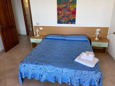 Letto o letti in una camera di Residence Il Borgo di Porto Corallo
