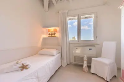 Letto o letti in una camera di Villa Bougainvillea con piscina e giardino privato a pochi passi dal mare