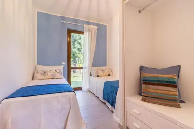 Letto o letti in una camera di Casa Azzurra - Casa con giardino privato a Costa Rei a due passi dal mare