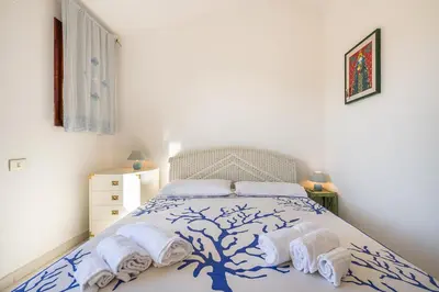 Letto o letti in una camera di Villa Cristina bella villa vista mare e porto turistico Loc Notteri Villasimiuss