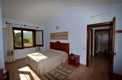 Letto o letti in una camera di Albergo Ristorante Pizzeria Monte Arcosu